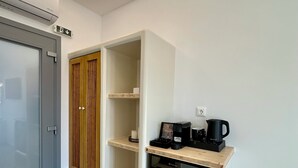 A modern kitchen with built-in appliances, a wooden cabinet, and a coffee station. - Marjay (Paros)