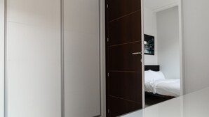 A bedroom with a bed, a wardrobe, and a framed picture on the wall.