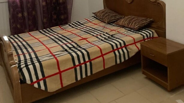 A bedroom with a wooden bed, a nightstand, and a chandelier. - Bagdadi region tourist area Mahdia sea view (mahdia)