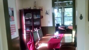Un comedor con una larga mesa, sillas y una araña.