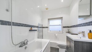 Une salle de bain moderne avec une douche à parois de verre, une baignoire et des toilettes.