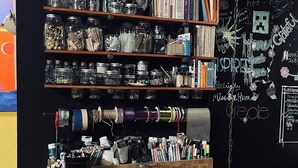 A bookshelf with jars and books, a chalkboard with writings, and a wooden cabinet. - Your Tranquil Abode on the Holiday Road (Tipp City)
