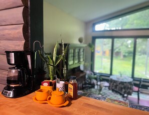A coffee station with a coffee maker, yellow cups, and a jar of honey. - Your Tranquil Abode on the Holiday Road (Tipp City)