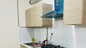 Una cocina moderna con armarios de madera, estufa a gas y campana extractora azul.