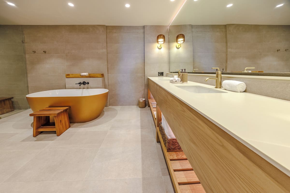Ein modernes Badezimmer mit einer freistehenden Badewanne, einem Holzwaschtisch und einem großen Spiegel.