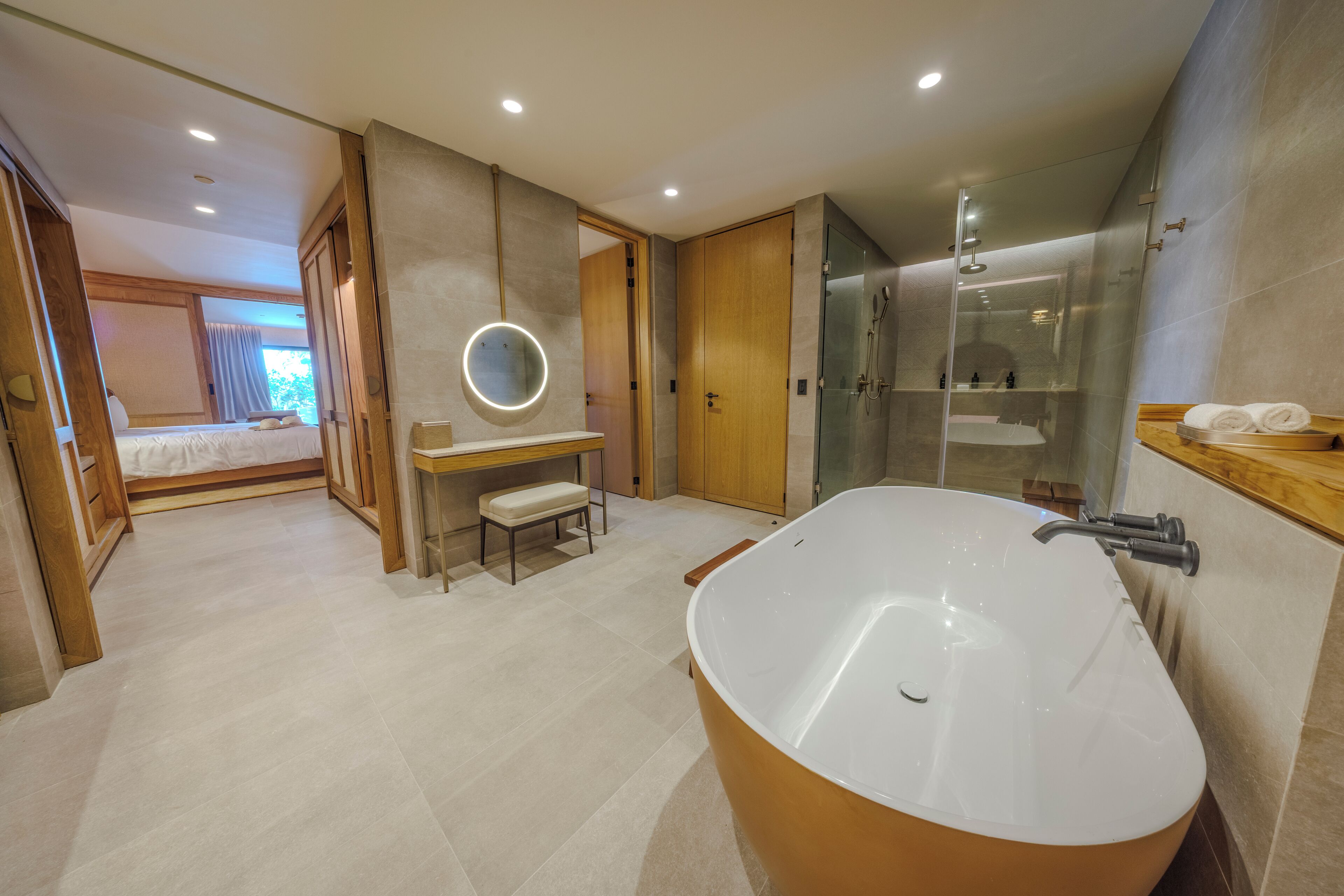 Un baño moderno con una bañera independiente, un tocador con espejo y una zona de ducha.