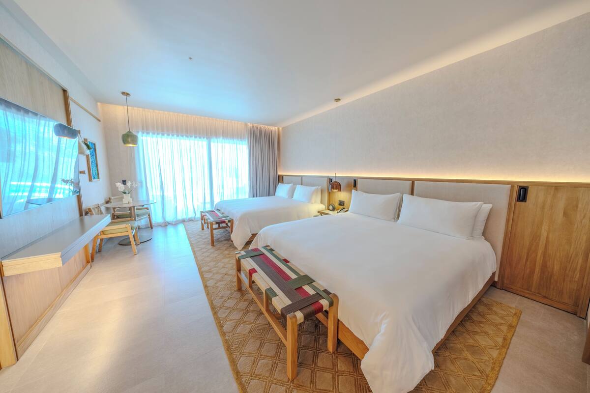 Ein Hotelzimmer mit einem großen Bett, einem Schreibtisch und einer Bank.