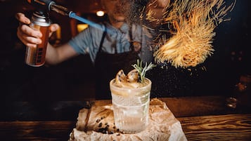 Une personne verse une boisson dans un verre à l’aide d’un shaker, et des étincelles jaillissent.