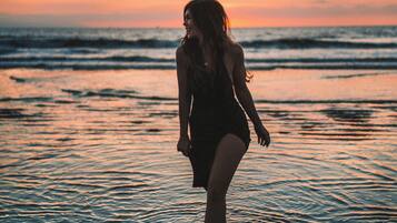 Uma pessoa caminhando na praia ao pôr do sol.