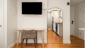 A modern kitchen with white cabinets, a wooden countertop, and a built-in oven. - Hygge House Suites (Newburyport)