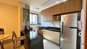 A compact kitchen with a refrigerator, microwave, and stove. - Studio Design 3 Apt 902 (Maceio)