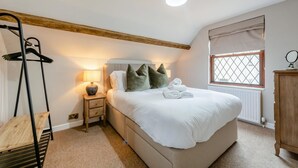 A bedroom with a bed, bedside table, lamp, and a window with a view. - 3 Bed in West Down (oc-r29627) (West Down)