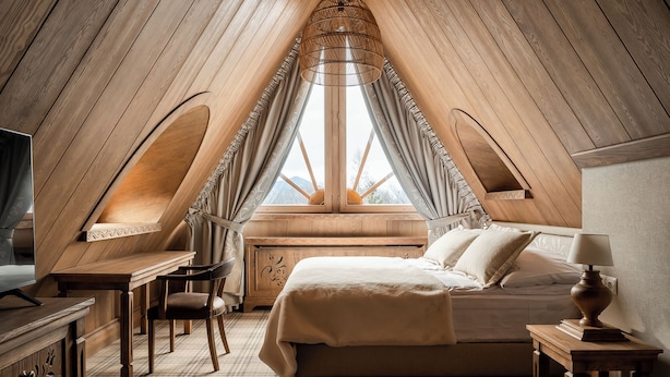 A bedroom with a sloped ceiling, a bed, a desk, and a chair. - Willa na Kozińcu (Zakopane)