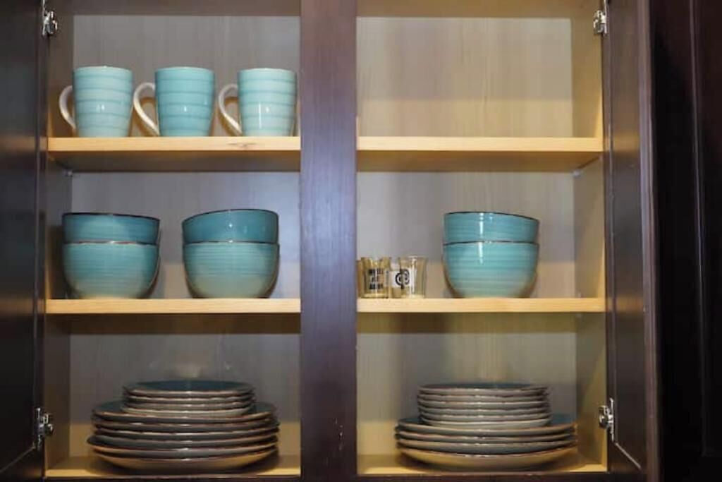 A cabinet with shelves holding blue bowls and plates.