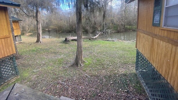 A wooden cabin with a view of a pond and trees. - The Preserve of Texas / C7 (Cleveland)