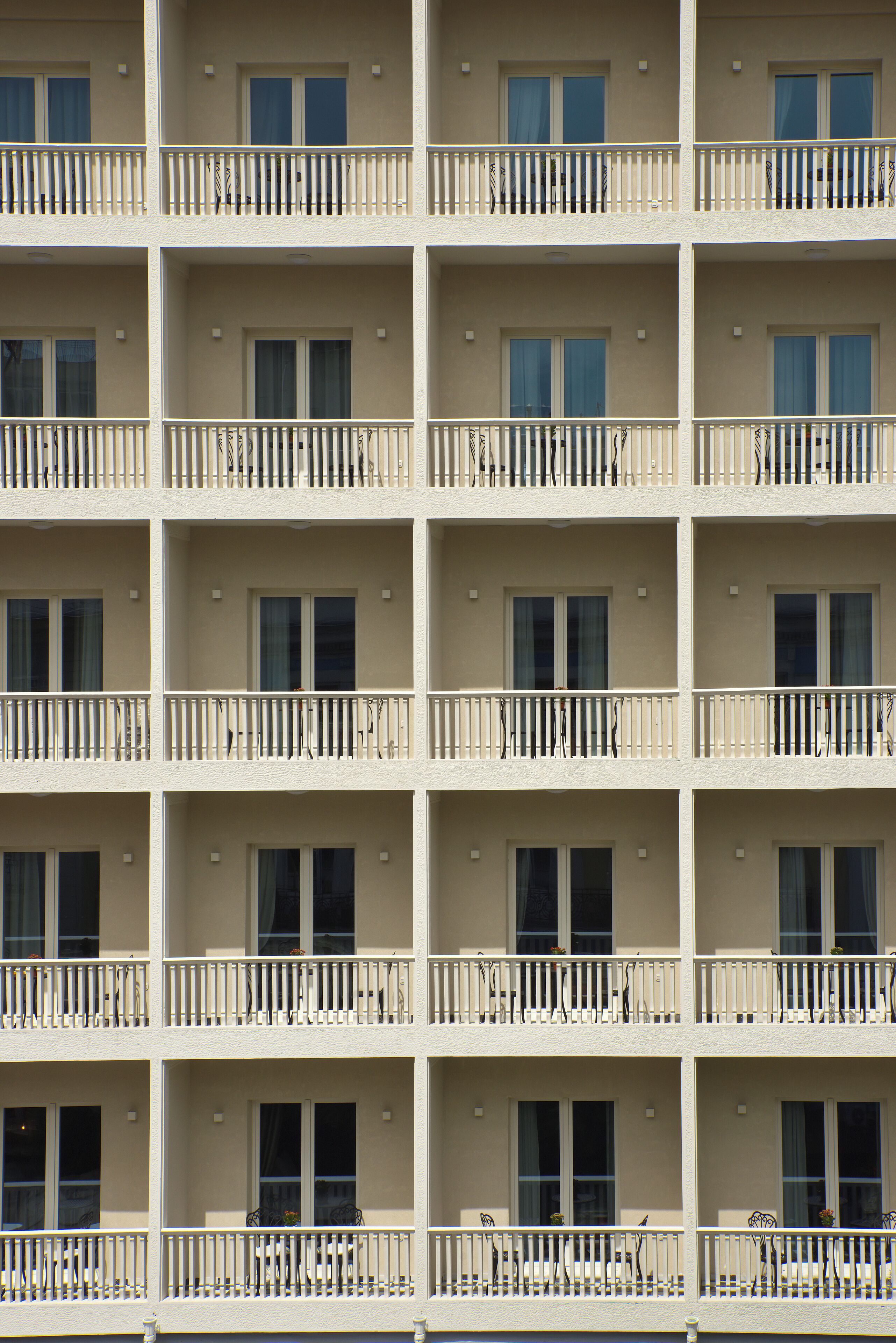 Un hotel de varios pisos con balcones, cada uno con barandilla y ventana.