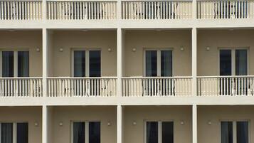 Un hotel de varios pisos con balcones, cada uno con barandilla y ventana.