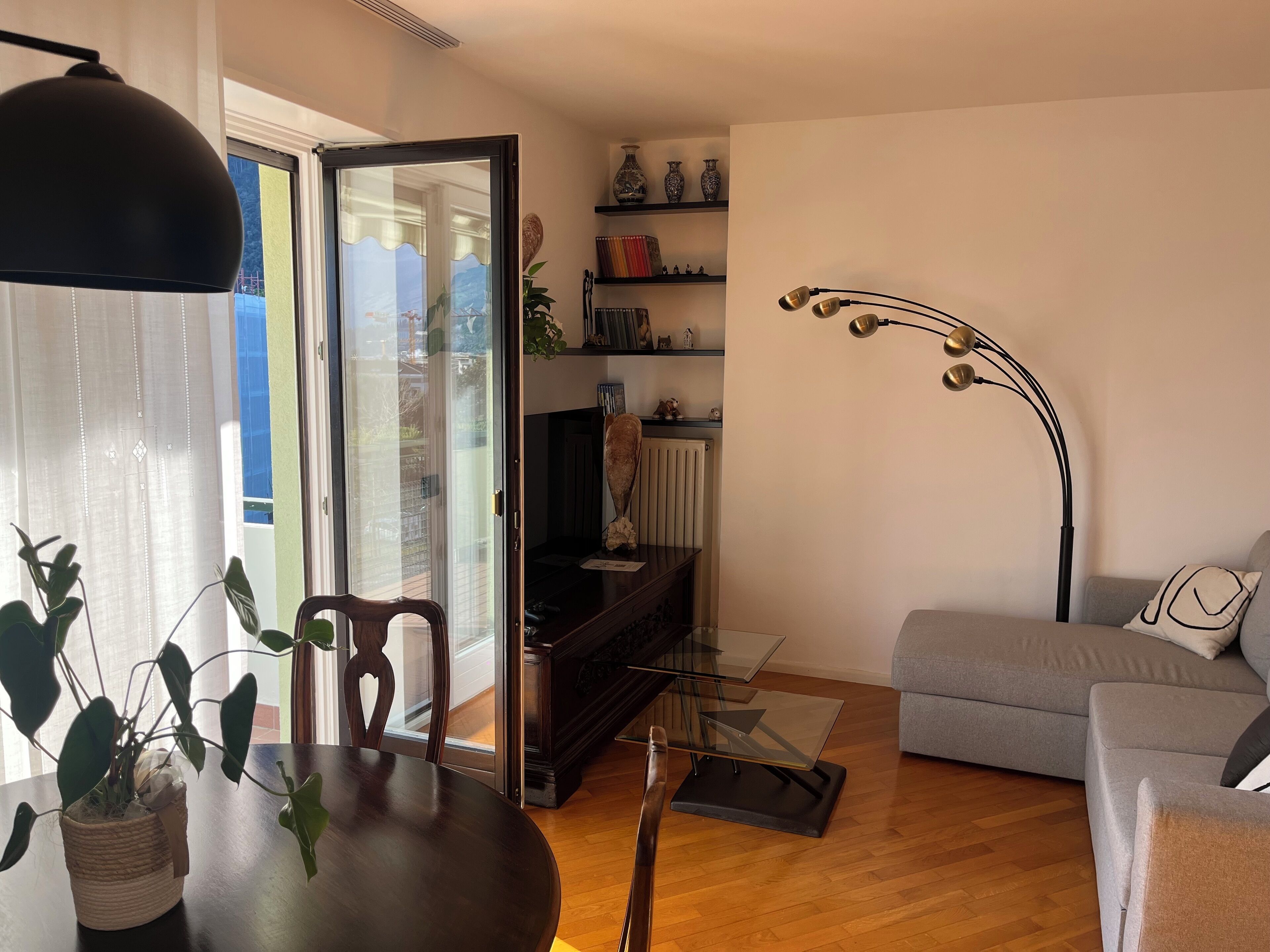 Un salon comprenant une table à manger, des chaises, un canapé, une lampe sur pied et une bibliothèque.