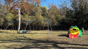 A playground with swings and a frog-shaped play structure.