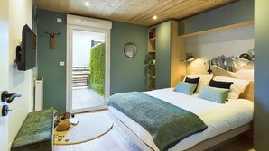 Een slaapkamer met een bed, nachtkastje en uitzicht op het omliggende landschap.