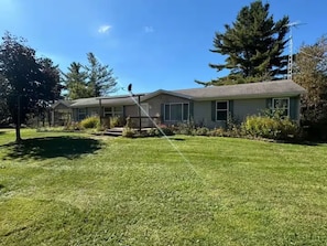 A two-story house with a well-maintained lawn and a satellite dish on the roof. - Northern Wilderness Memories (Dafter)