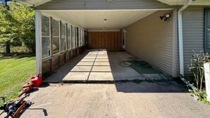 Un garage fermé avec un plancher en bois, de grandes fenêtres et une décoration en forme de papillon sur le mur.