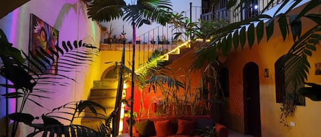 Un espace intérieur accueillant, doté d’un escalier, d’un coin salon et de diverses plantes.