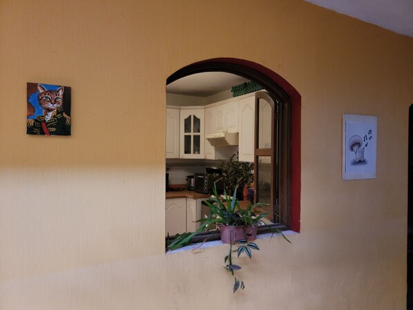 A kitchen with white cabinets, a window with a view, and a potted plant on the windowsill.
