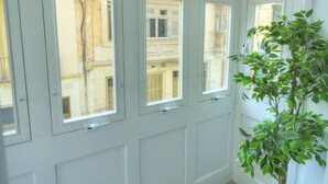 A corner room with multiple windows, a potted plant, and a tiled floor. - Chic, bright and modern 3 bedrooms KBAS1-1 (Gzira)