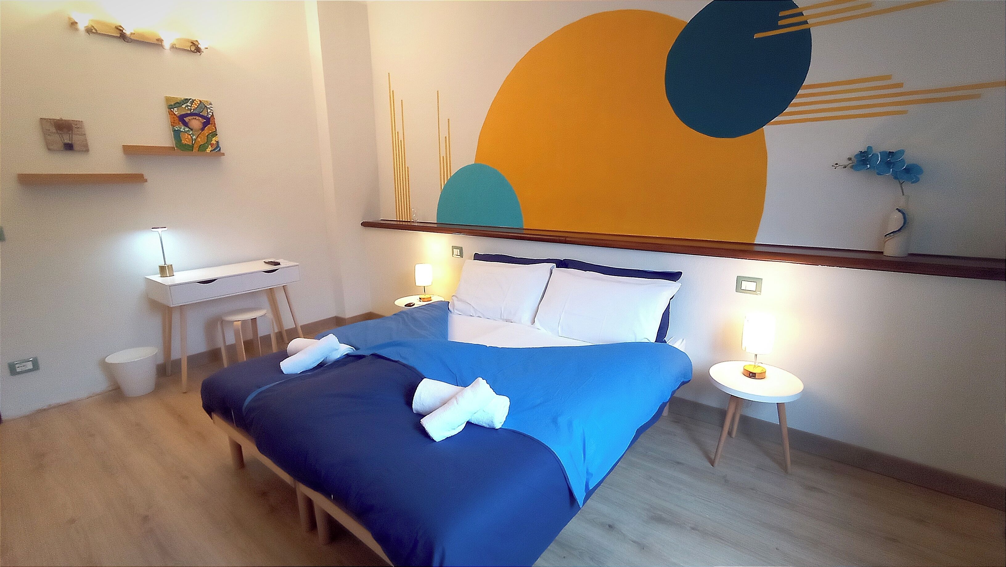 Ein modernes Hotelzimmer mit Bett, Nachttischen, Schreibtisch und Stuhl.