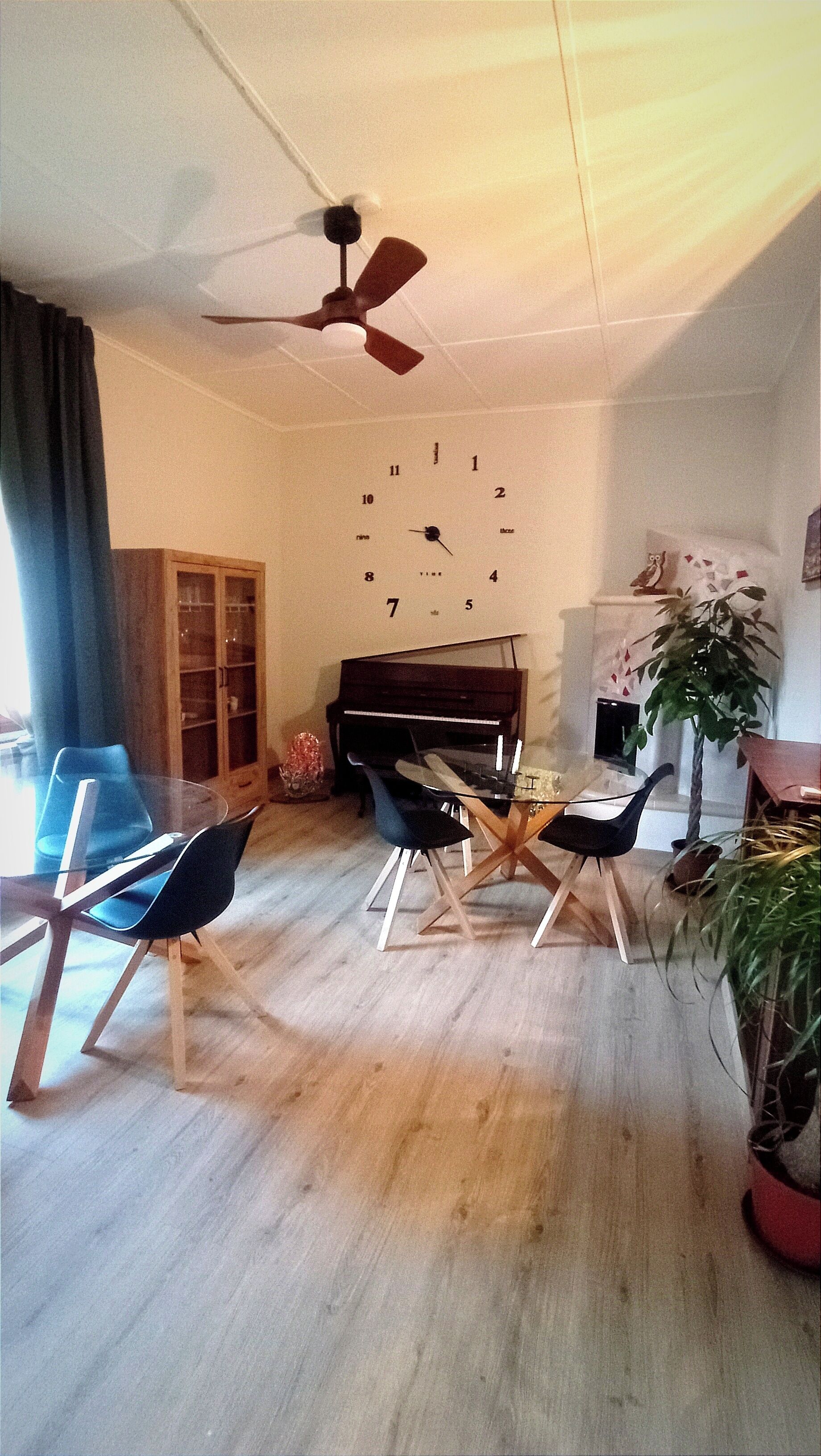 Ein Wohnzimmer mit einem Klavier, einem Glastisch und zwei Sesseln.
