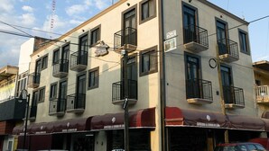 A multi-story building with balconies, a sign for 'Hotel Cascada', and storefronts with awnings. - Hotel Cascada el Garruño (Calvillo)