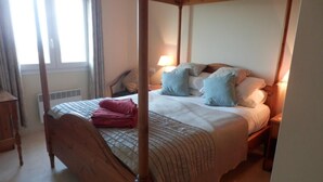 A four-poster bed with a quilt and pillows, a bedside table, and a lamp. - 6 Guests - Private Pool - 3Br Villa - Amazing View (Orba)