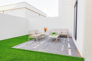 A patio with two sofas, a coffee table, and a potted plant. - Bloomfields 3BR Townhouse Noya in Yas (Abu Dhabi)