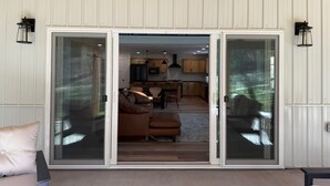 Amplia sala de estar con puerta corrediza de vidrio que da a una cocina y comedor.