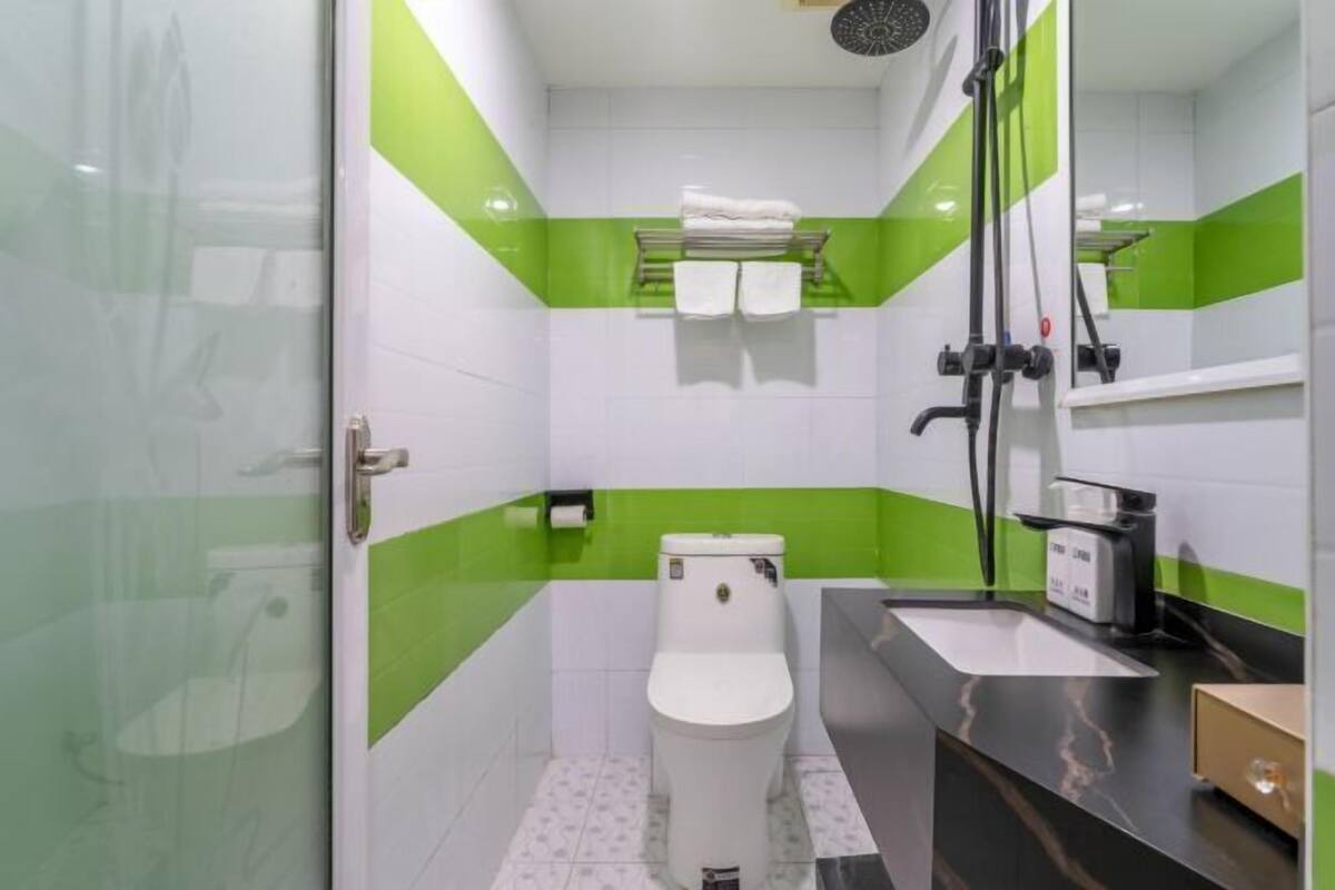 Une salle de bain avec des toilettes, un lavabo et une douche.
