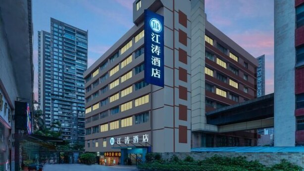 A hotel with a prominent sign, multiple floors, and a modern architectural design. - Jiangtao Hotel Guangzhou (Guangzhou)