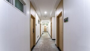 A hotel hallway with doors, a patterned floor, and a light fixture on the ceiling. - Jiangtao Hotel Guangzhou (Guangzhou)