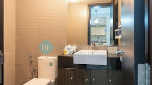 A bathroom with a toilet, a sink, and a mirror.