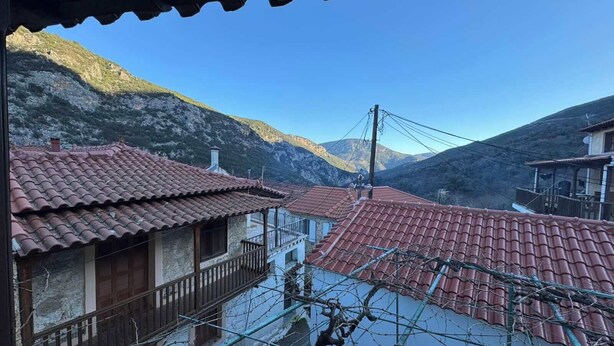 A traditional building with a tiled roof, a balcony, and a mountainous backdrop. - Fani's house (Platanos)