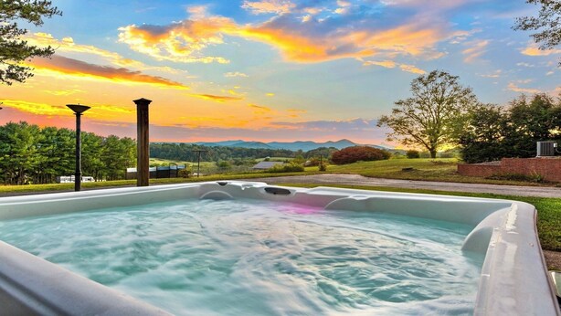 Un bain à remous avec vue sur un coucher de soleil et les montagnes.