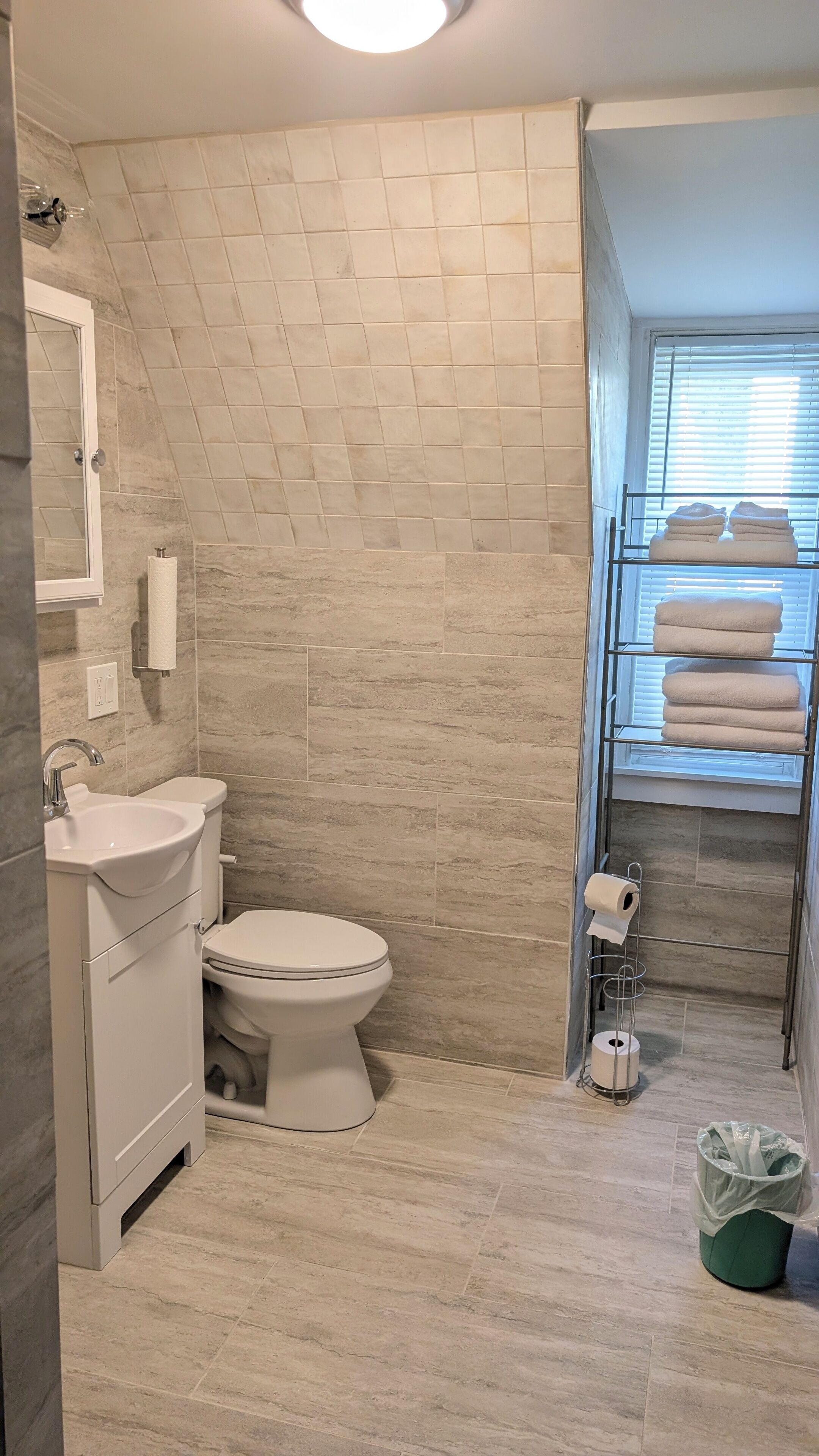 Une salle de bain comprenant des toilettes, un lavabo, un porte-serviettes et une fenêtre.