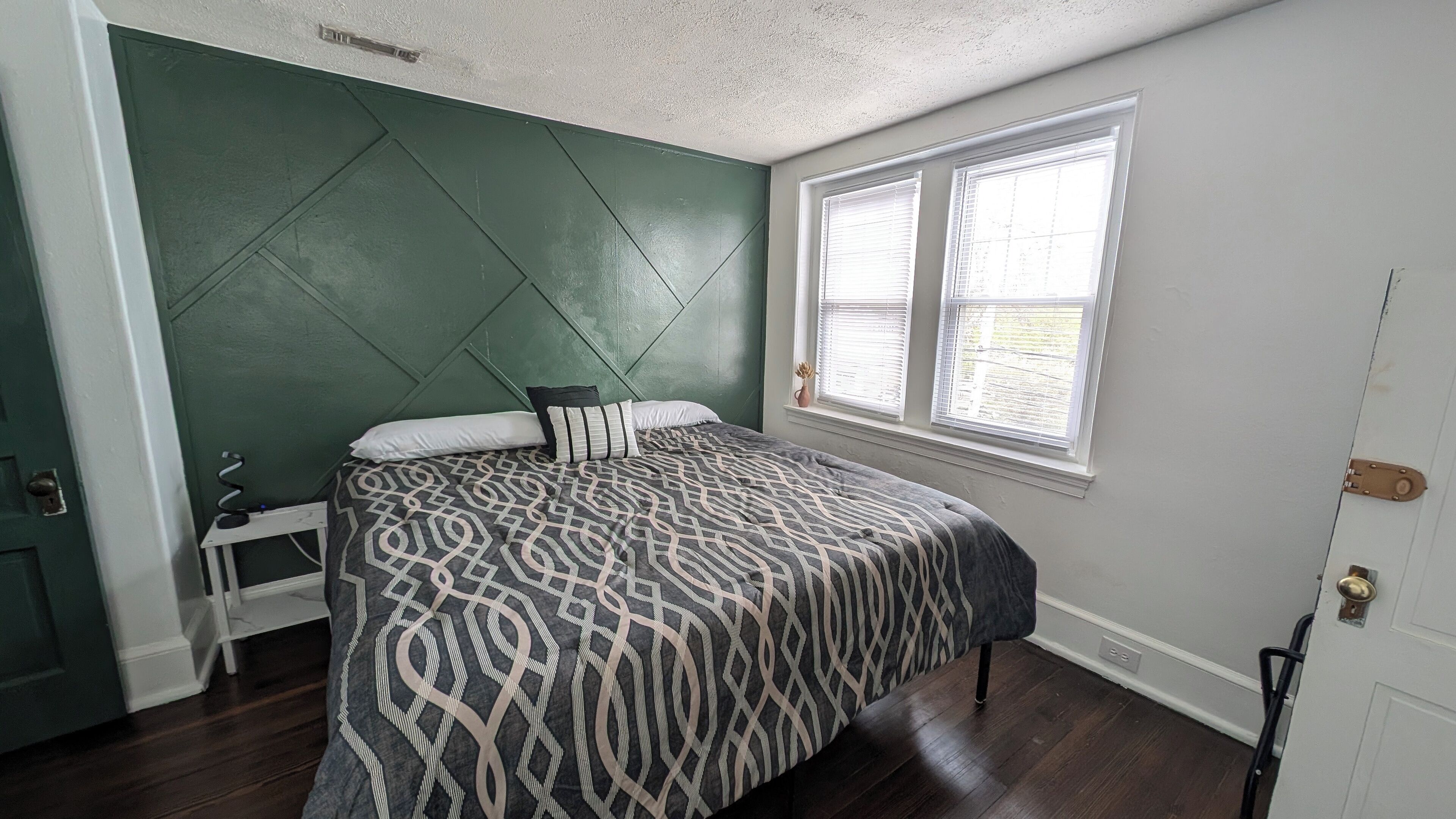 Un dormitorio con cama, ventana y puerta.
