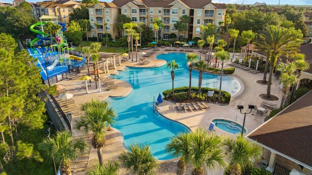 Ein Resort mit einem großen zentralen Pool, einem Wasserpark und einem Gebäude mit mehreren Balkonen.