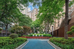 A residential area with a pathway, greenery, and high-rise buildings in the background. - Jiugang Hotel (Shanghai)