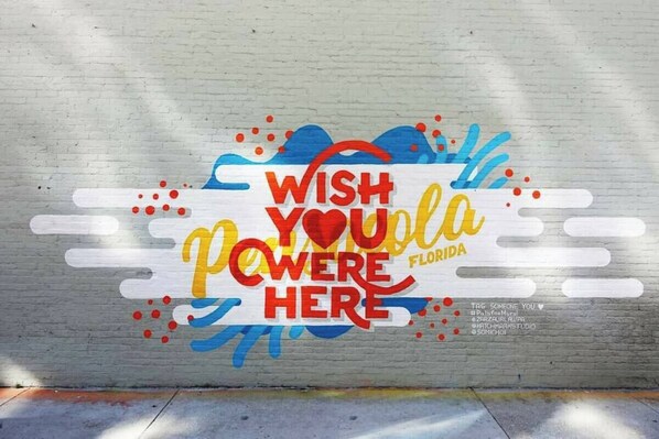 A wall with a colorful mural that says 'WISH YOU'RE POWERED HERE' and 'Florida' with a heart symbol.