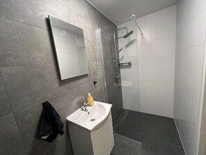 Een douche, handdoeken, zeep, toiletpapier