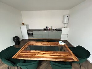 Een koelkast met diepvriezer, een microgolfoven, een oven, een kookplaat