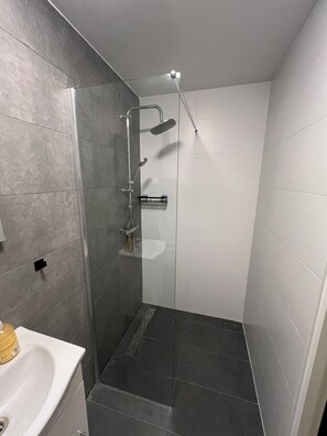 Een douche, handdoeken, zeep, toiletpapier