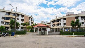 A gated residential complex with multiple apartment buildings, a central pavilion, and a paved entrance area.